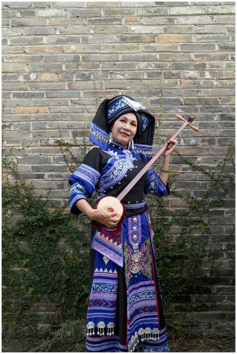 Zhuang woman in colorful traditional attire with s