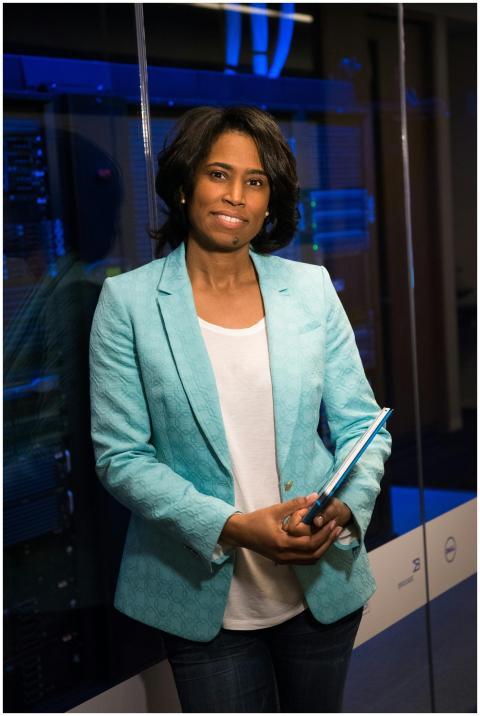 Confident woman in a server room, holding a tablet