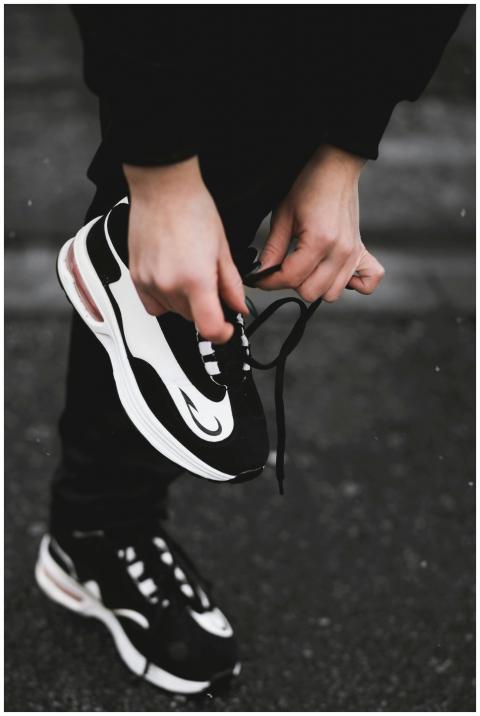 Close-up of an athlete tying black and white sneak