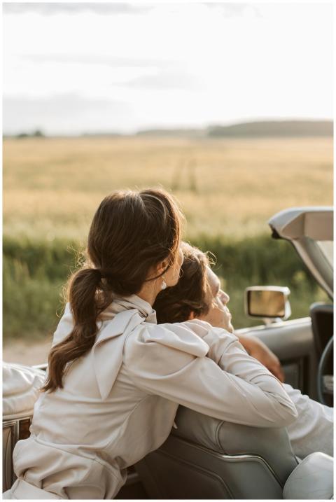 A couple in a convertible embraces during a scenic