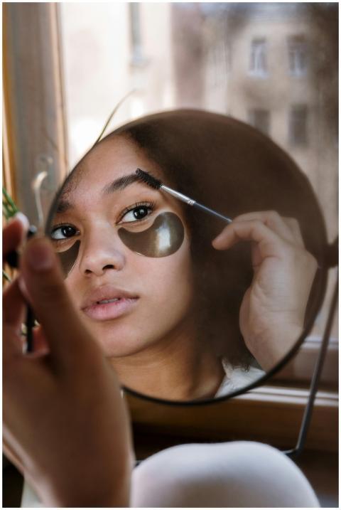 A reflective moment of a young woman applying make