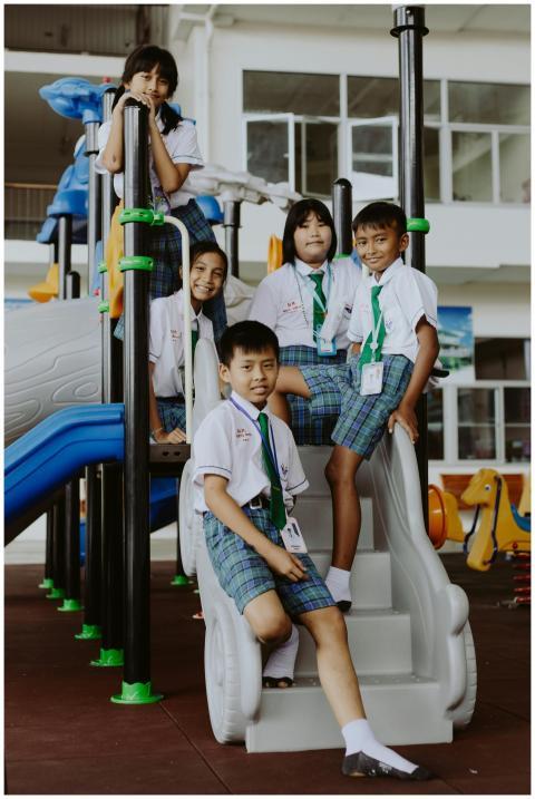 Children in school uniforms enjoying fun at the pl