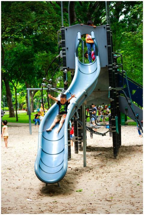 Children having fun on a slide in a lively park pl