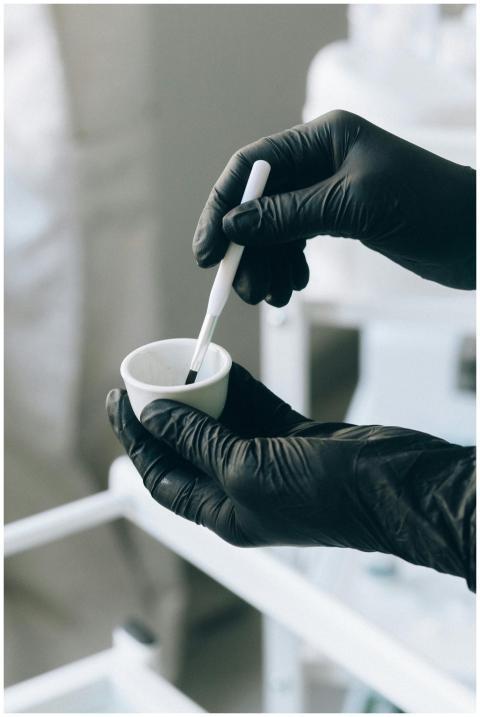 Close-up of hands applying permanent makeup with p