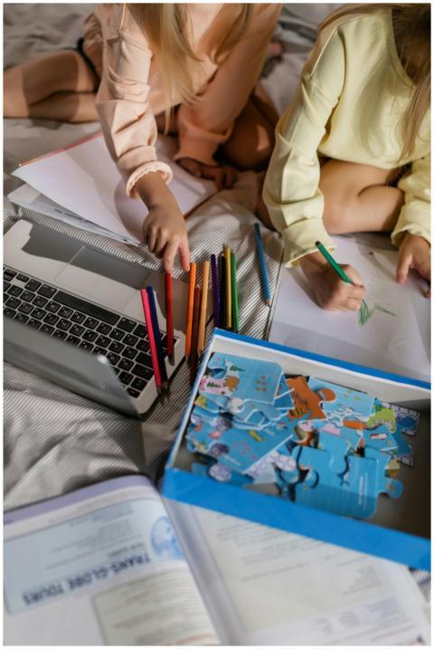 Two children drawing and solving puzzles at home,