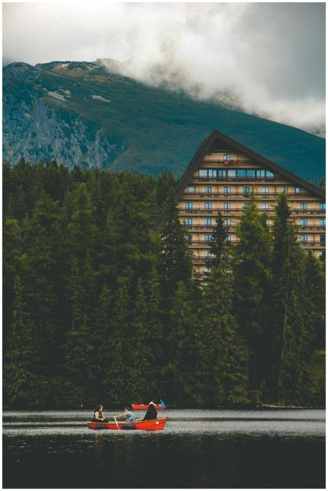 Picturesque lake with a red boat, surrounded by fo
