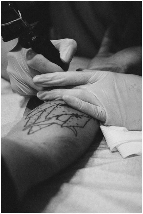 Close-up black and white photo of a tattoo artist