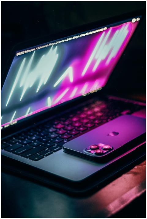 Vibrant illuminated laptop screen with smartphone,