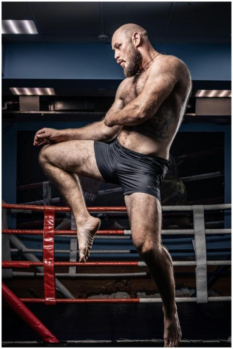 Powerful kickboxer performs dynamic move in a gym