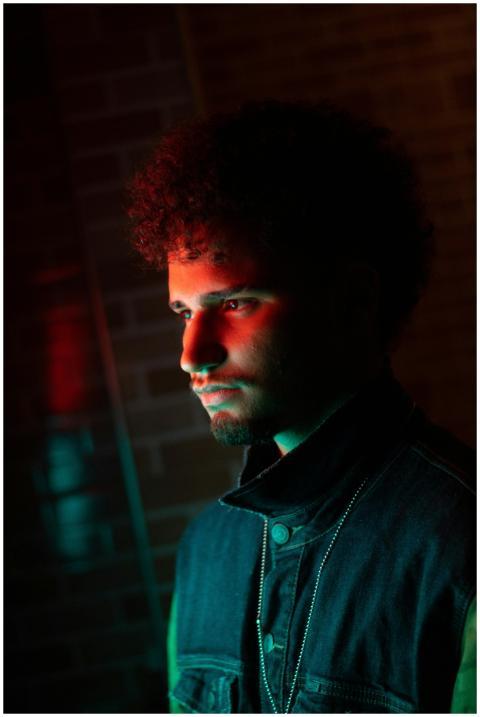 Side view of a young man with afro hair in moody l