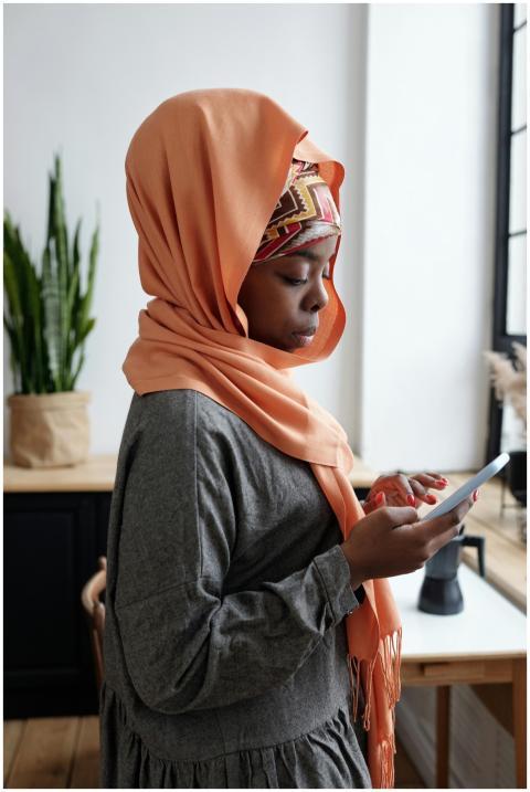 Side view portrait of a modern Muslim woman using