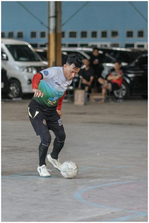 A soccer player skillfully dribbling a ball indoor