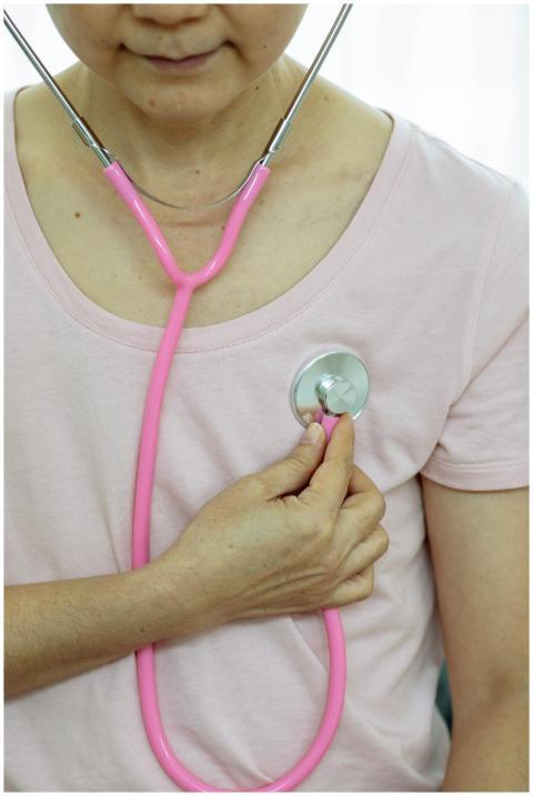Middle-aged woman in pink shirt using a pink steth