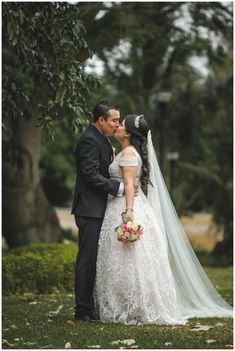 Delightful outdoor wedding scene with a couple kis