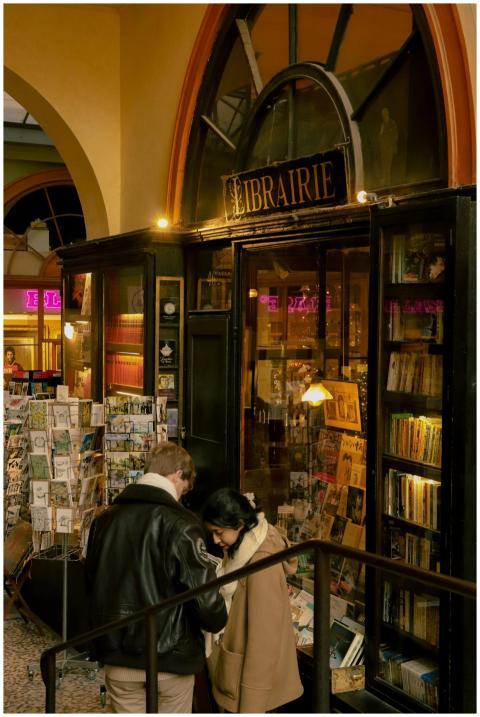 Customers browsing outside a charming Parisian boo