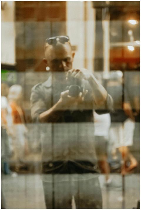 Blurry reflection of a man taking a photo through