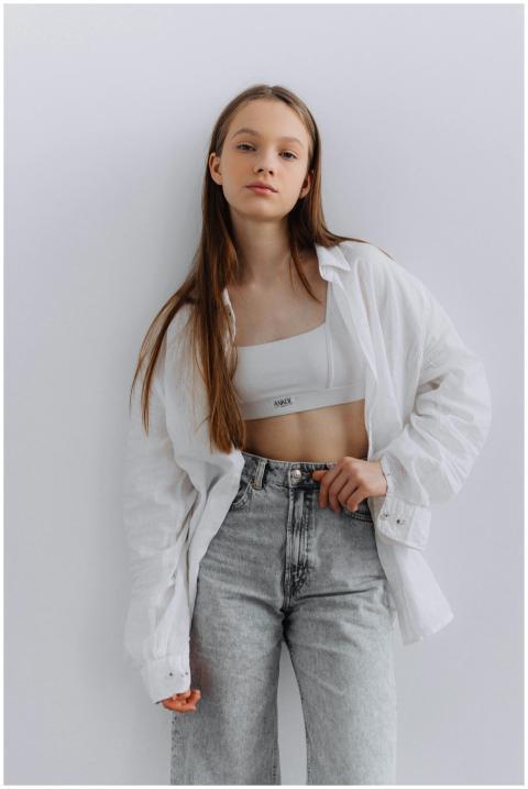 Stylish young woman posing in white shirt and deni