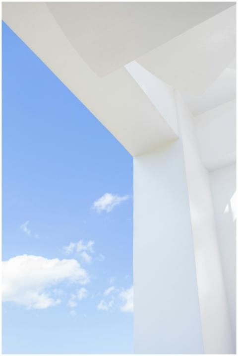 Sleek white structure with blue sky and clouds, sh