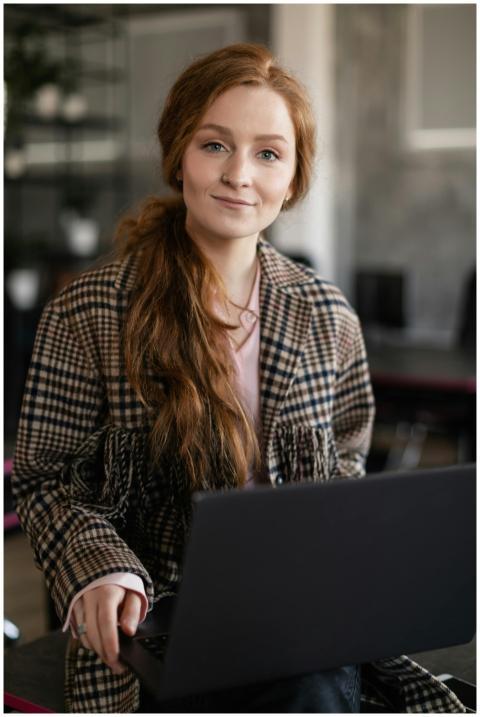 Portrait of a young woman with red hair holding a