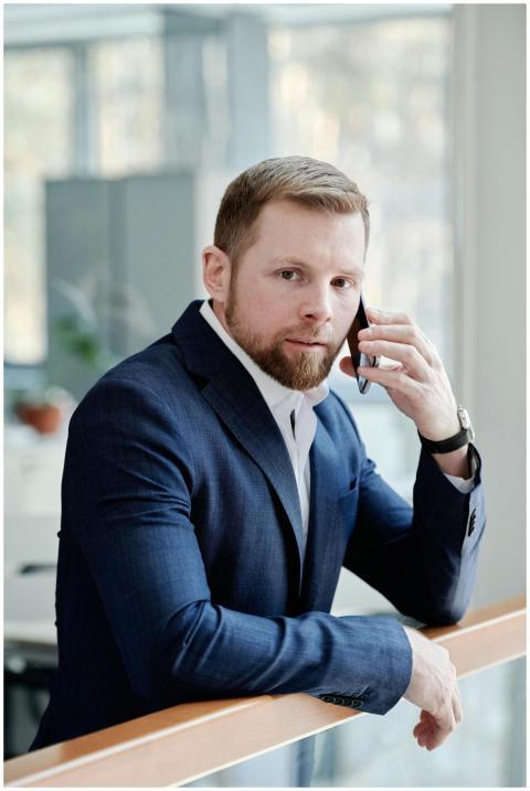 Businessman in blue suit talking on phone indoors,