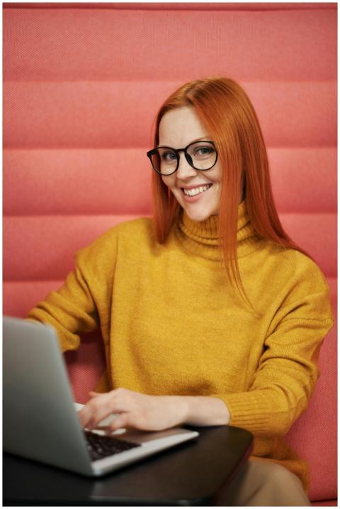 Confident woman smiling while working on a laptop