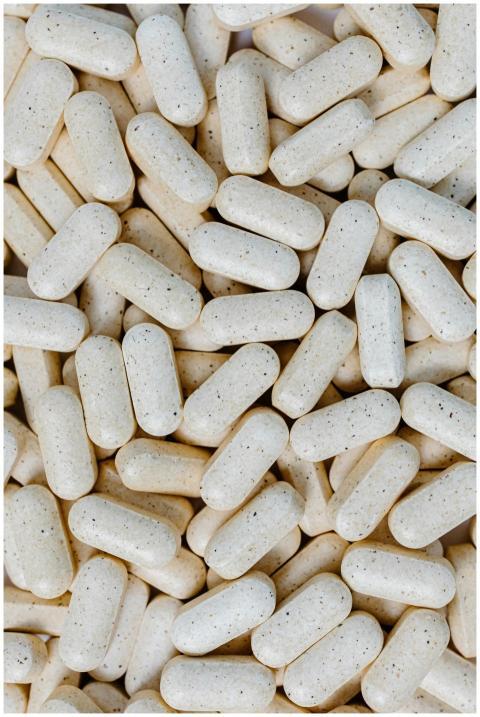 Detailed close-up of numerous white pills, showcas