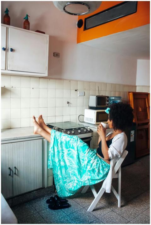 Woman sitting in cozy kitchen enjoying coffee, emb