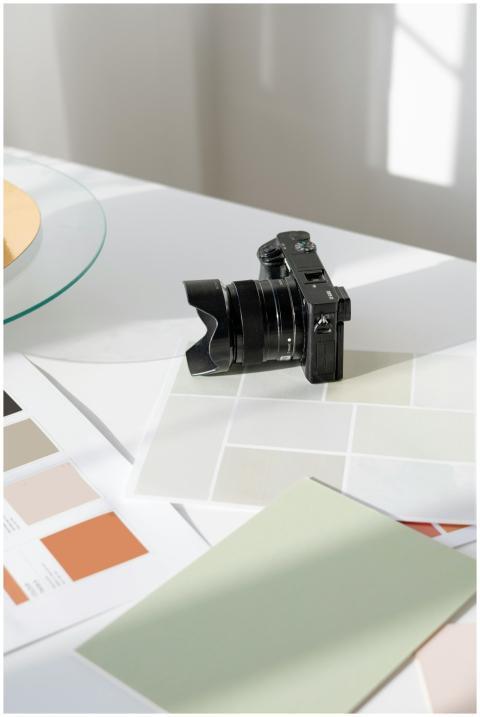 Digital camera resting on a desk with color swatch