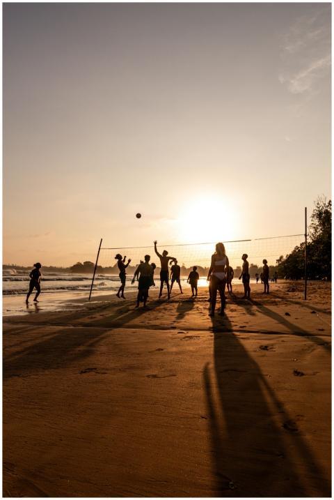 A lively beach volleyball game at sunset on Weliga