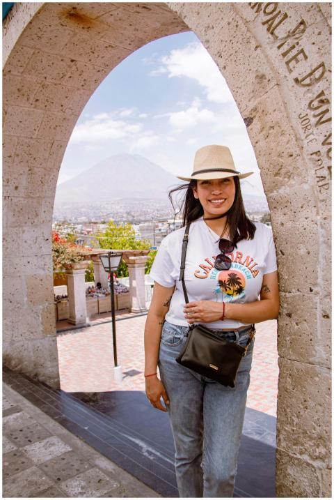 A woman wearing casual attire smiles under a histo