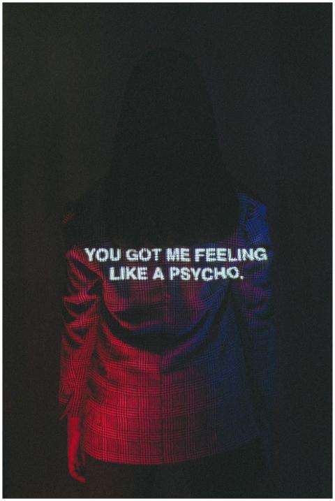 A woman with text projected on her blazer, creatin