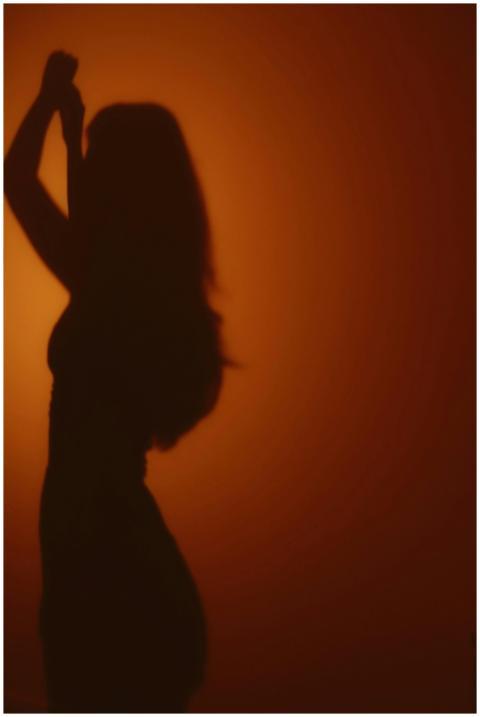 Artistic silhouette of a woman against a warm suns