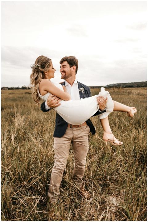 A joyful, loving couple in a field, embracing unde