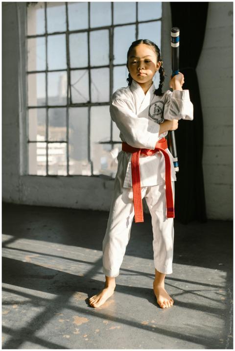 Focused young martial artist practicing indoors wi