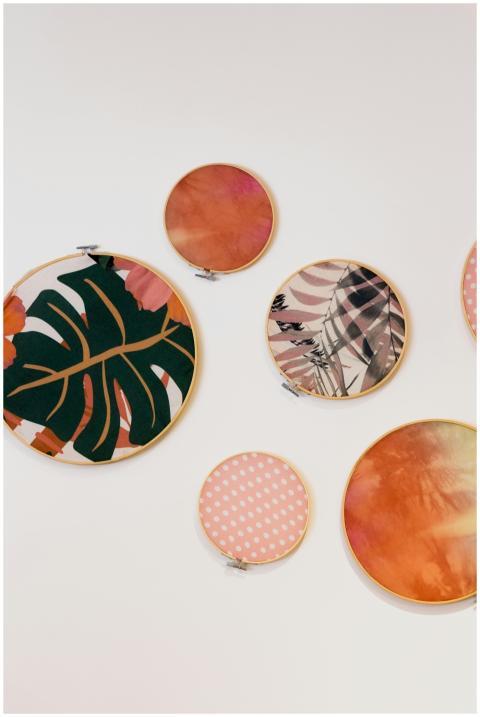 A vibrant display of circular embroidery hoops wit