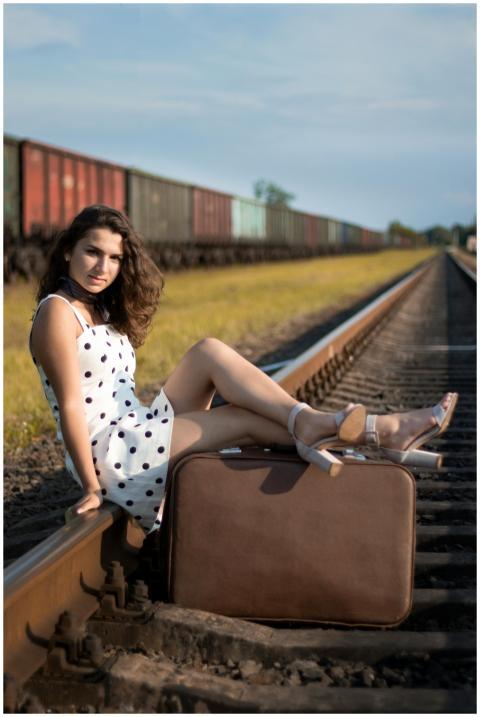 Young woman in polka dot dress posing on railway t