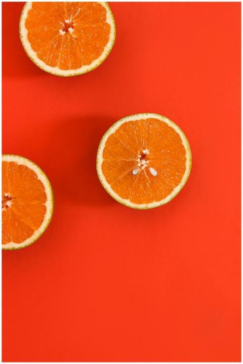 Top view of fresh orange slices placed on a red su