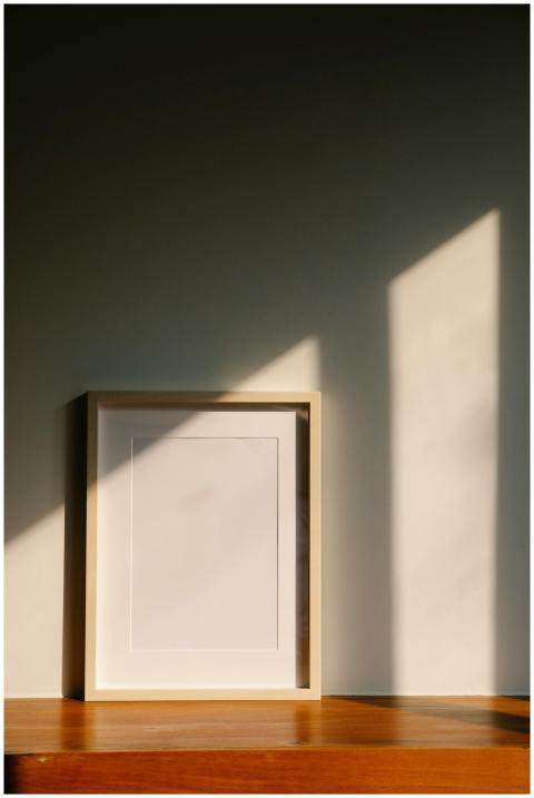 Elegant minimalist frame on a wooden shelf, bathed