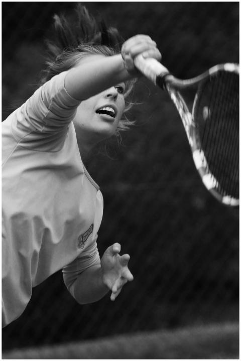 Black and white image of a woman serving in a tenn