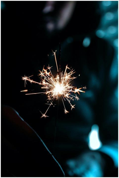 A bright sparkler crackling in the foreground agai