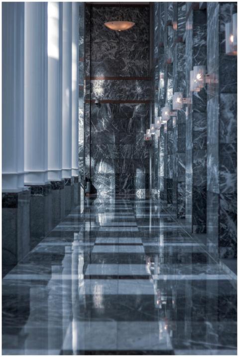 Sleek modern hallway featuring marble walls and fl