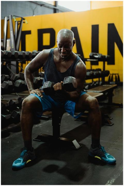 An athletic man working out with dumbbells in a vi