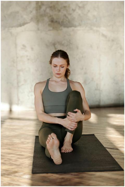 A woman practices yoga indoors, promoting flexibil