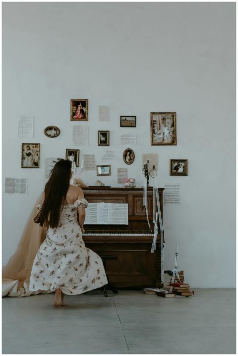 Woman in a floral dress playing a vintage piano wi