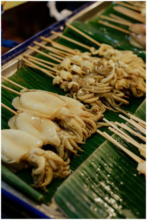 Close-up of grilled squid skewers on banana leaves