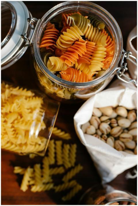 Top view of glass jars with uncooked fusilli and r