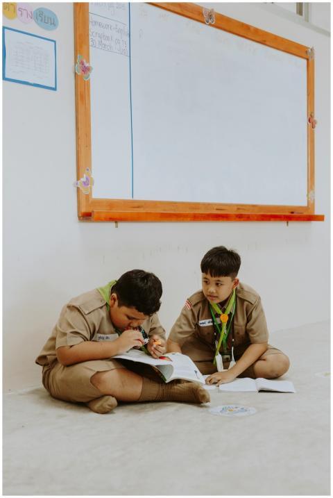 Two boys in uniform studying in a classroom, foste