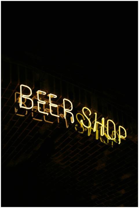 Close-up of an illuminated neon beer shop sign aga