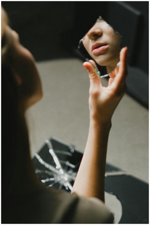 Close-up of a teenage girl holding a broken mirror
