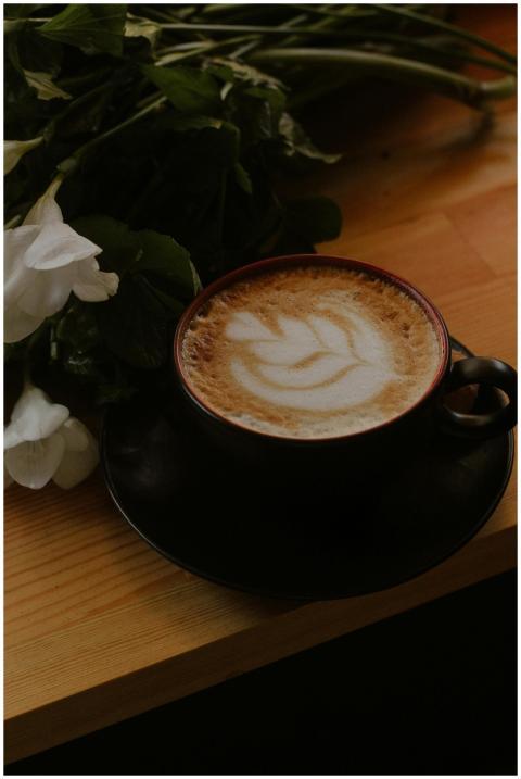 A beautifully crafted latte in a black cup with de